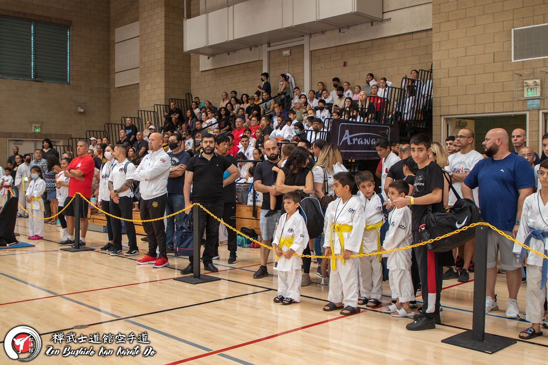A group of people are standing in a line in a gym.