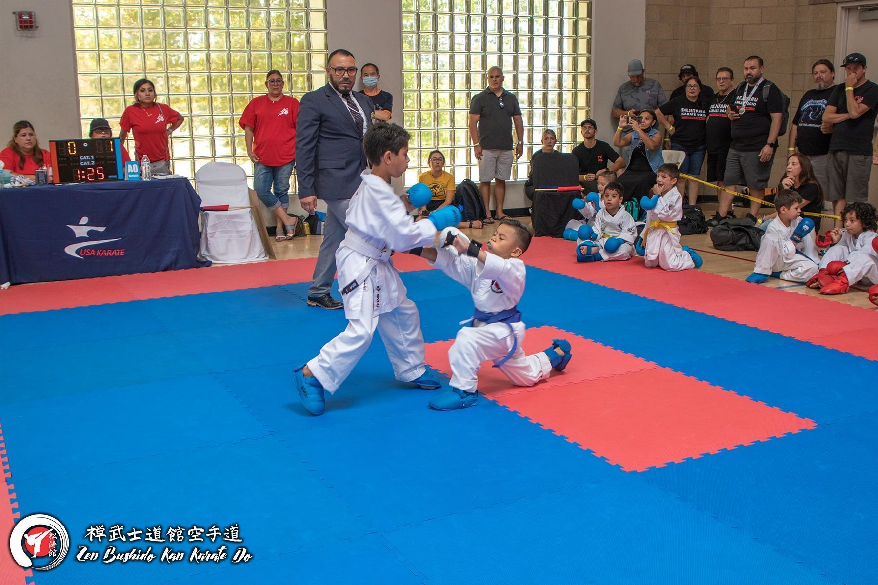 A group of young boys are playing karate on a mat.