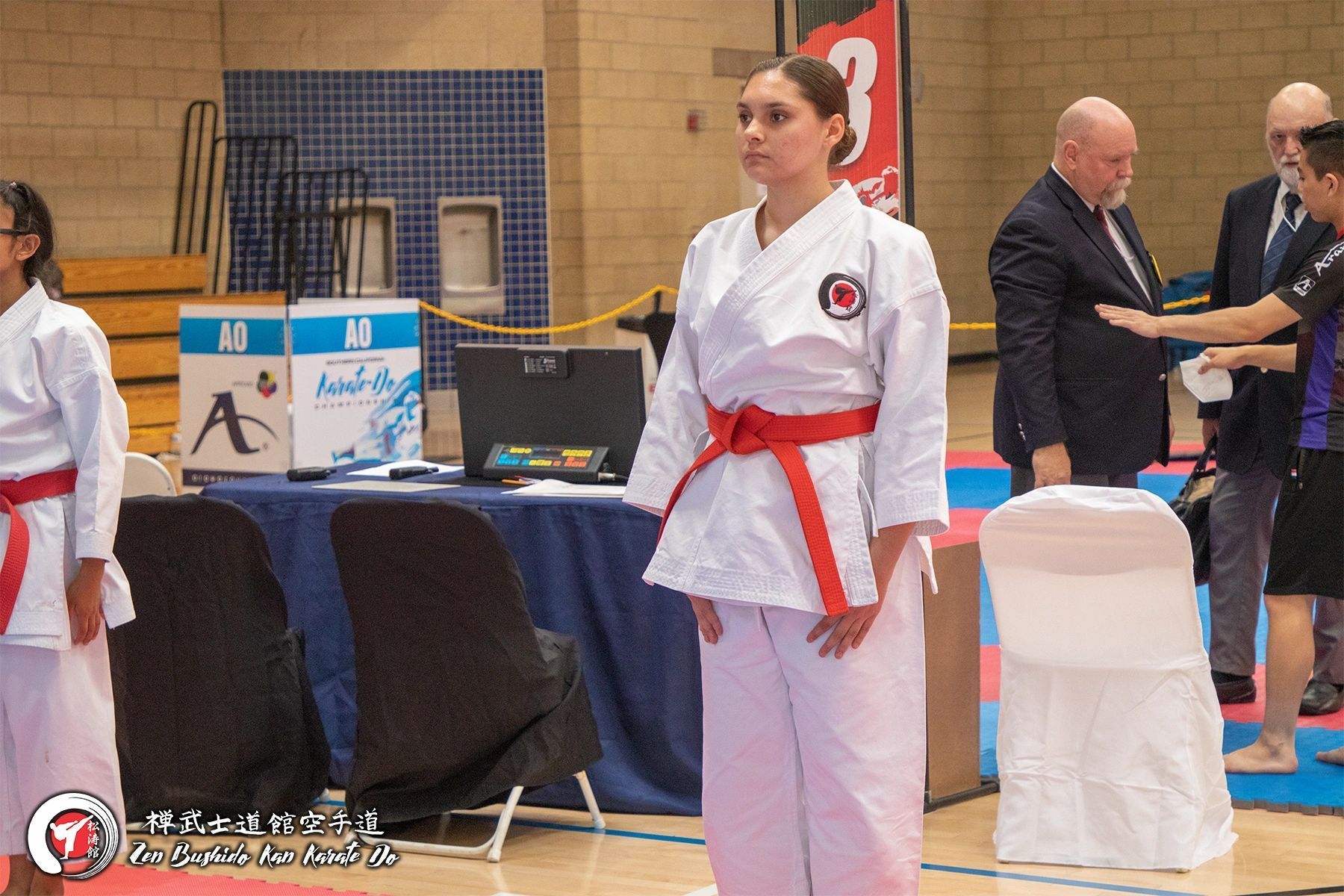 A woman in a white karate uniform with a red belt