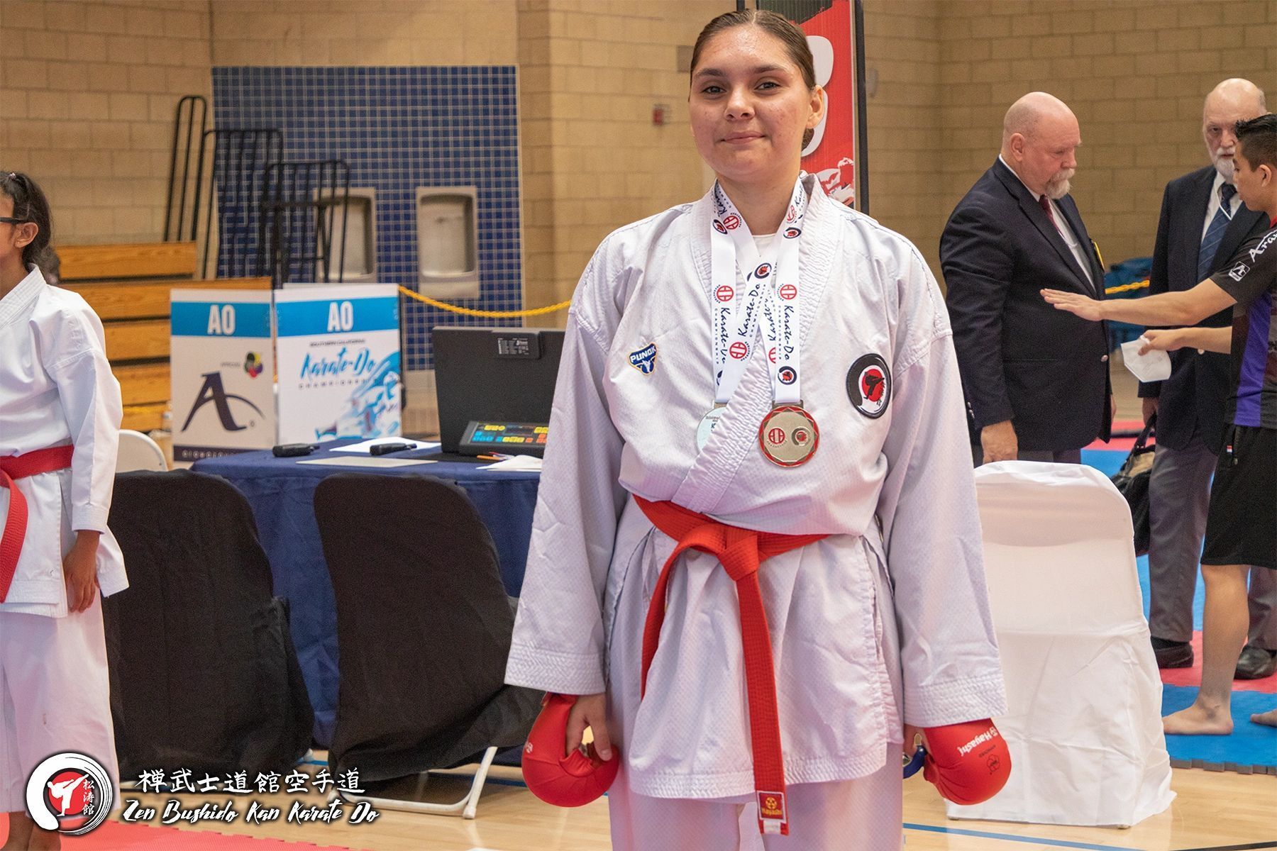 A woman in a karate uniform with a medal around her neck