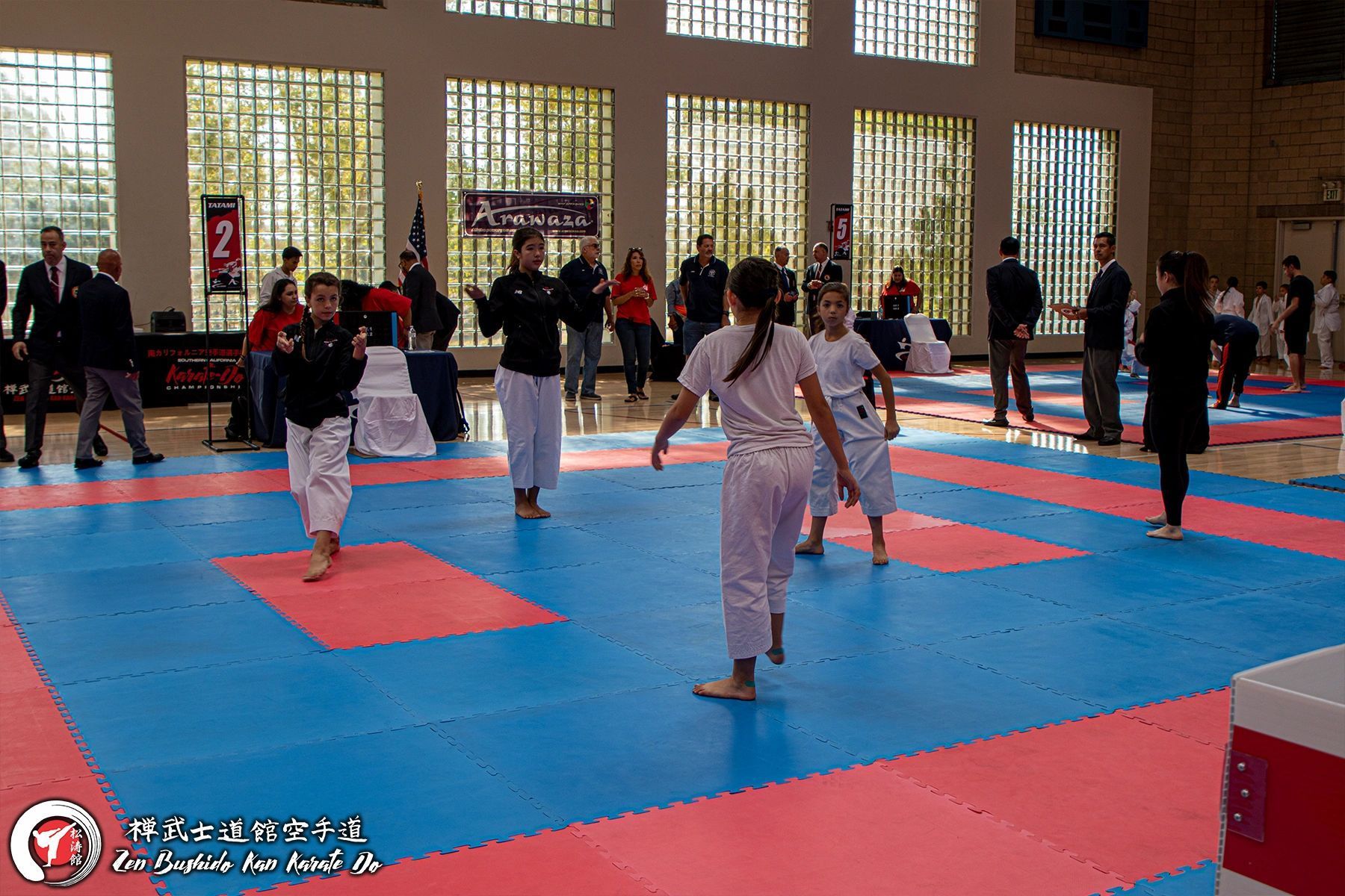 A group of people are practicing martial arts in a gym