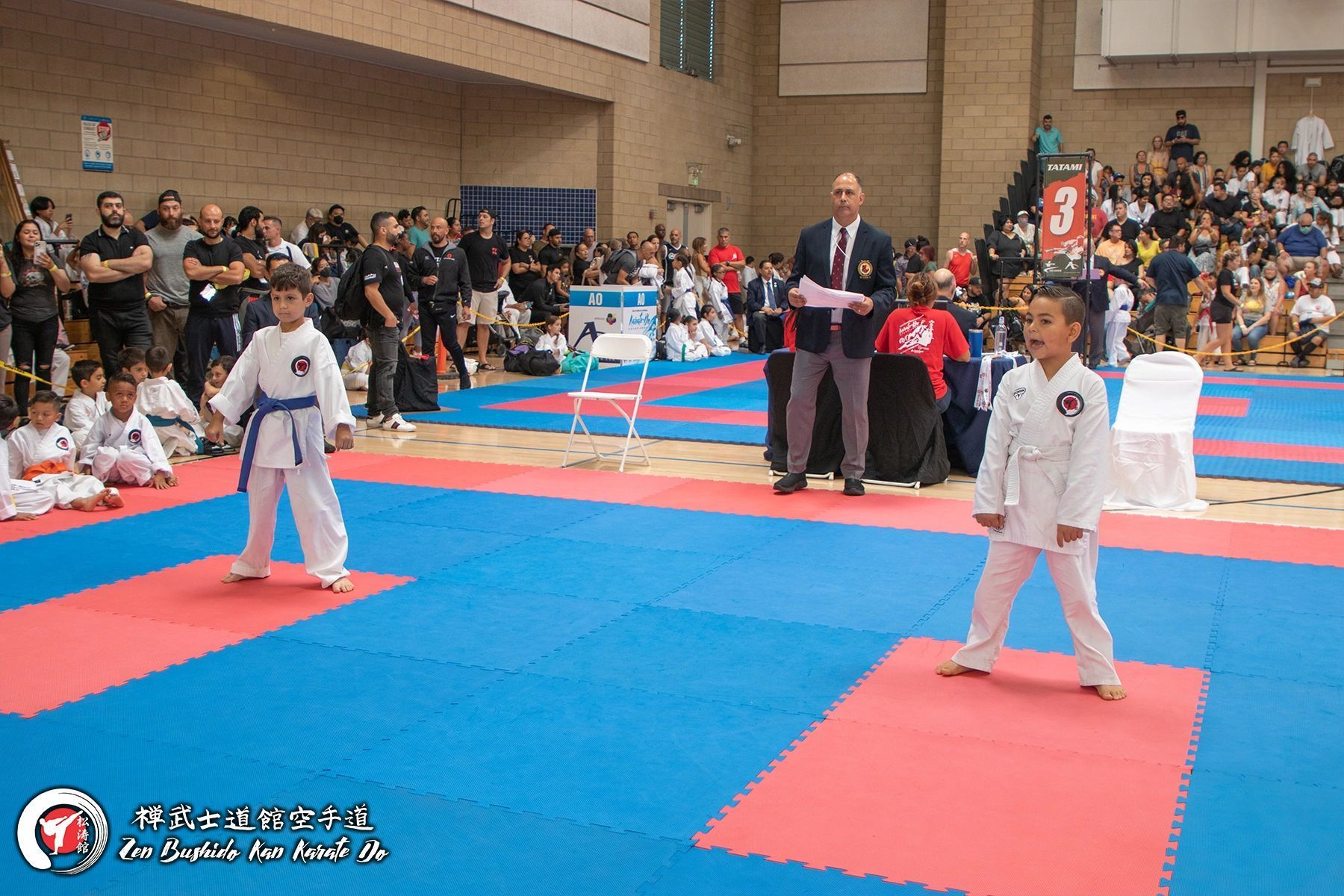 A group of young boys are practicing martial arts in a gym.