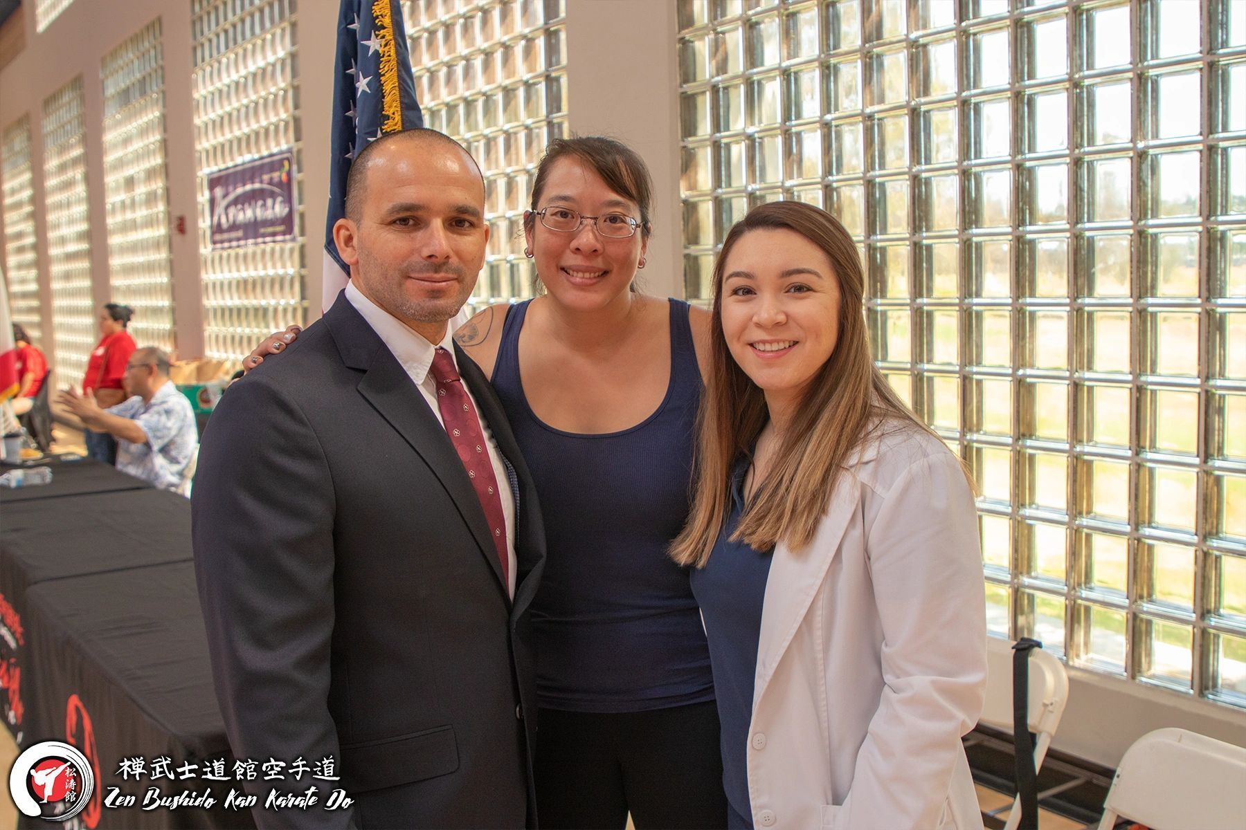 A man in a suit and tie is posing for a picture with two women.