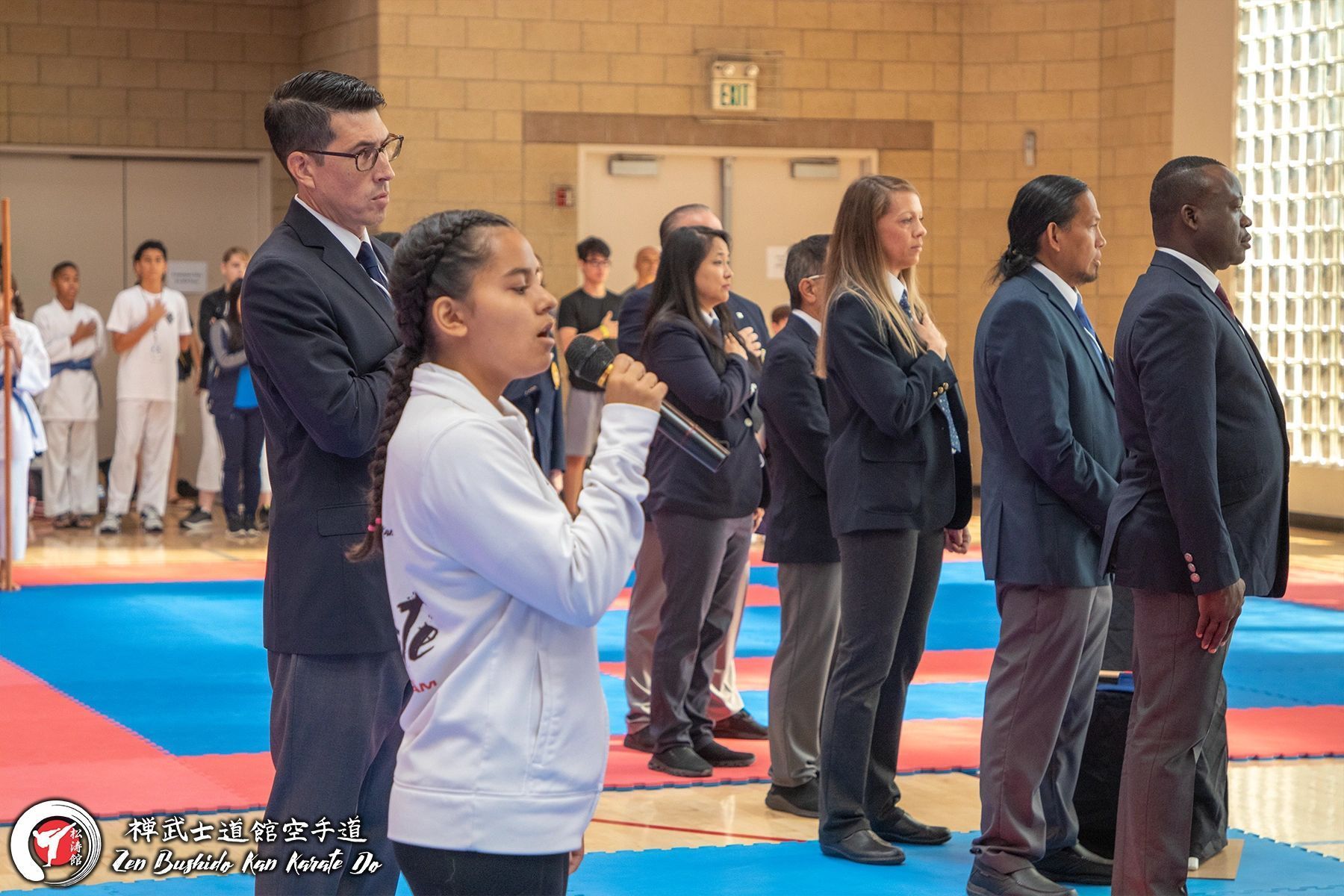 A group of people are standing in a line in a gym.