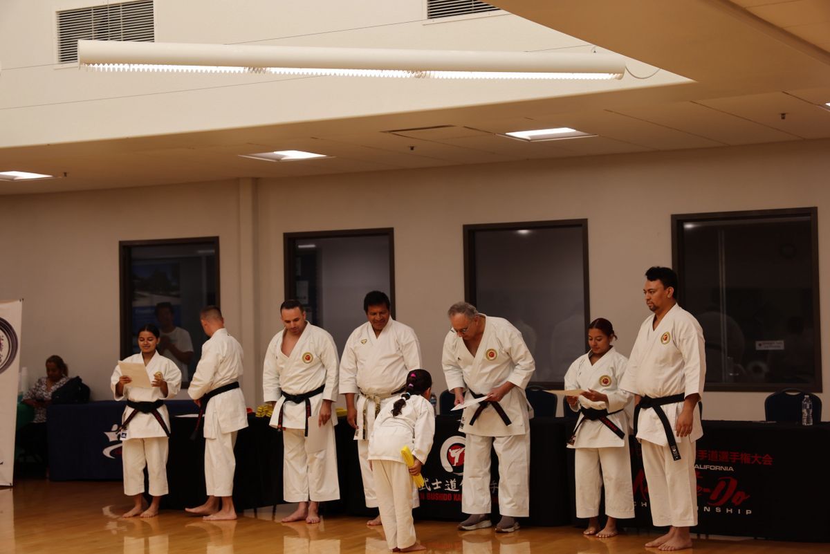A group of people in karate uniforms are standing in a room