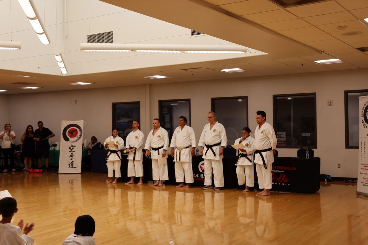 A group of people in karate uniforms are standing in a room