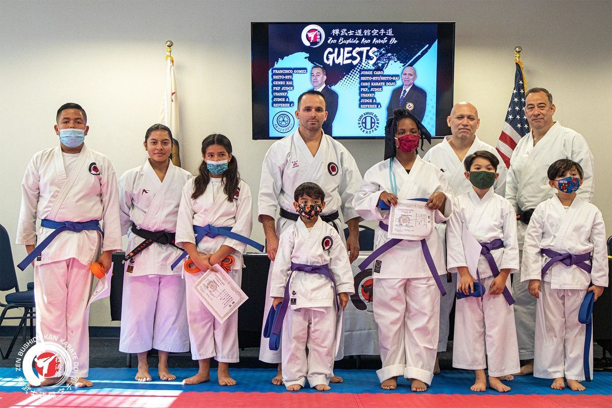 A group of people in karate uniforms are posing for a picture.