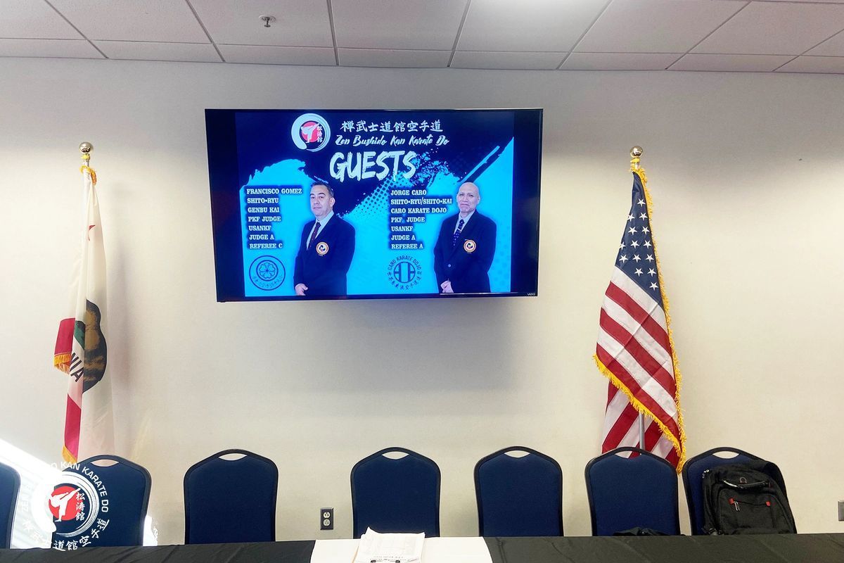 A conference room with a large screen on the wall that says guests