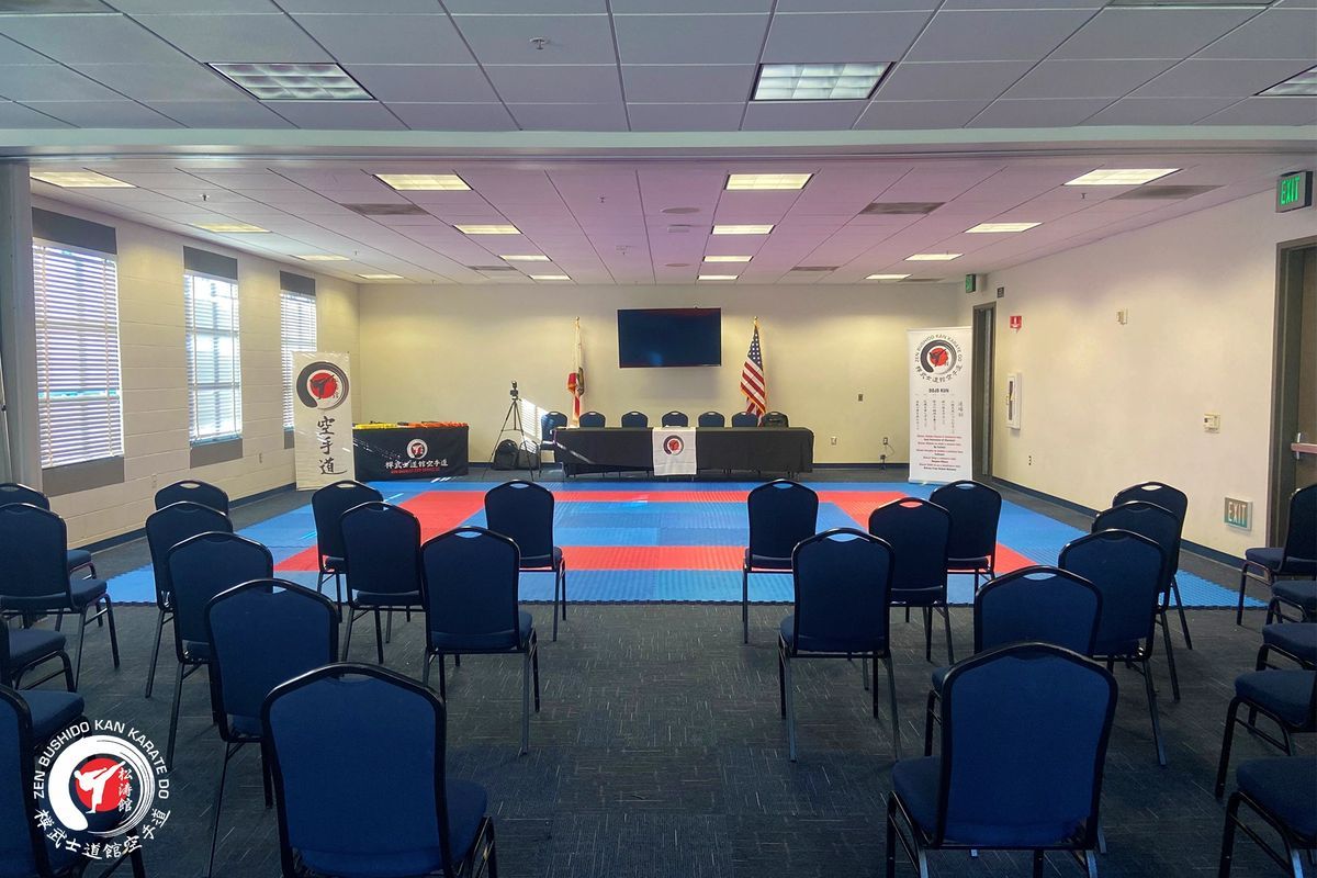 A large room with rows of chairs and a karate mat.