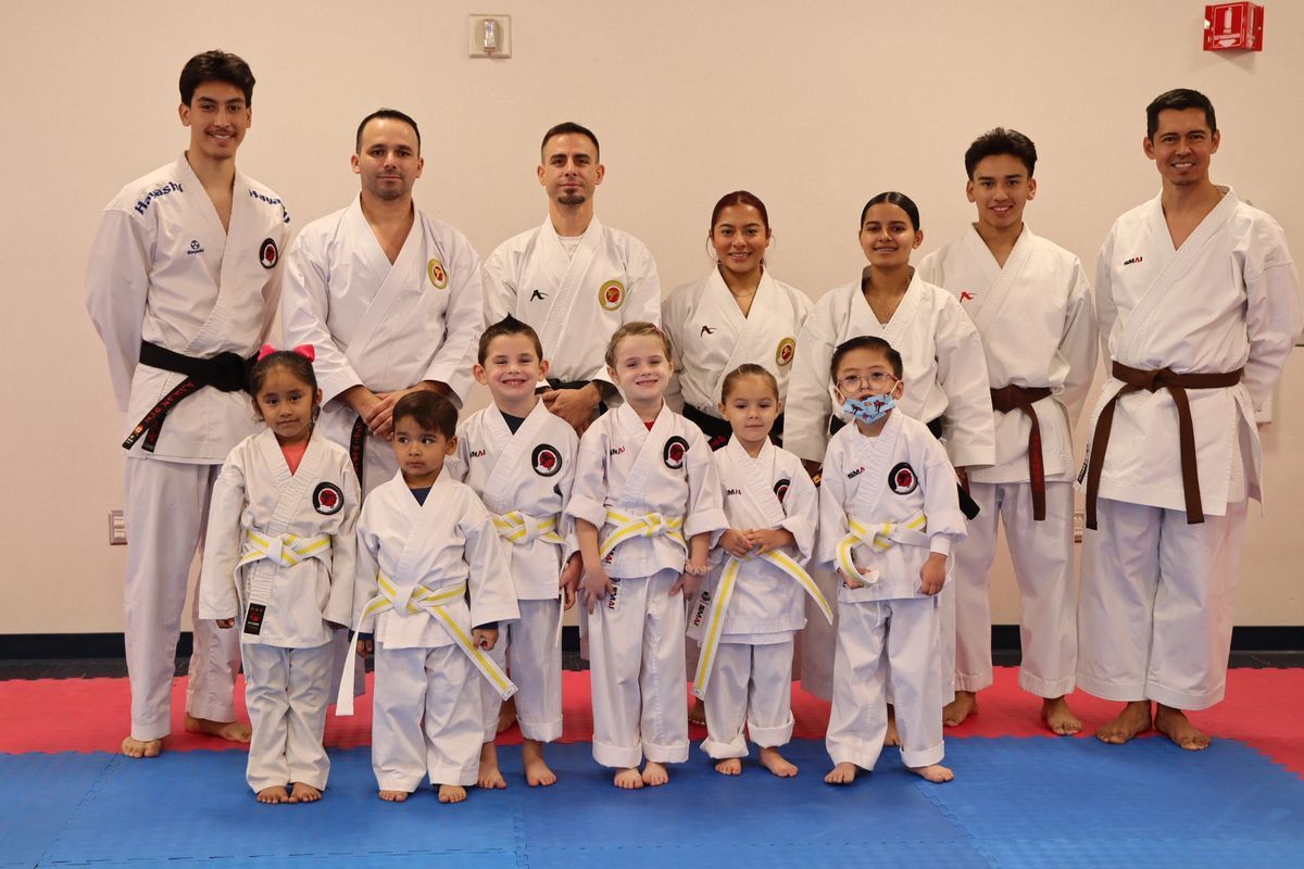 A group of people in karate uniforms are posing for a picture.