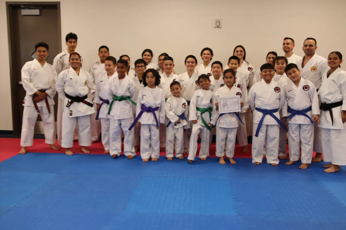 A group of people in karate uniforms are posing for a picture.