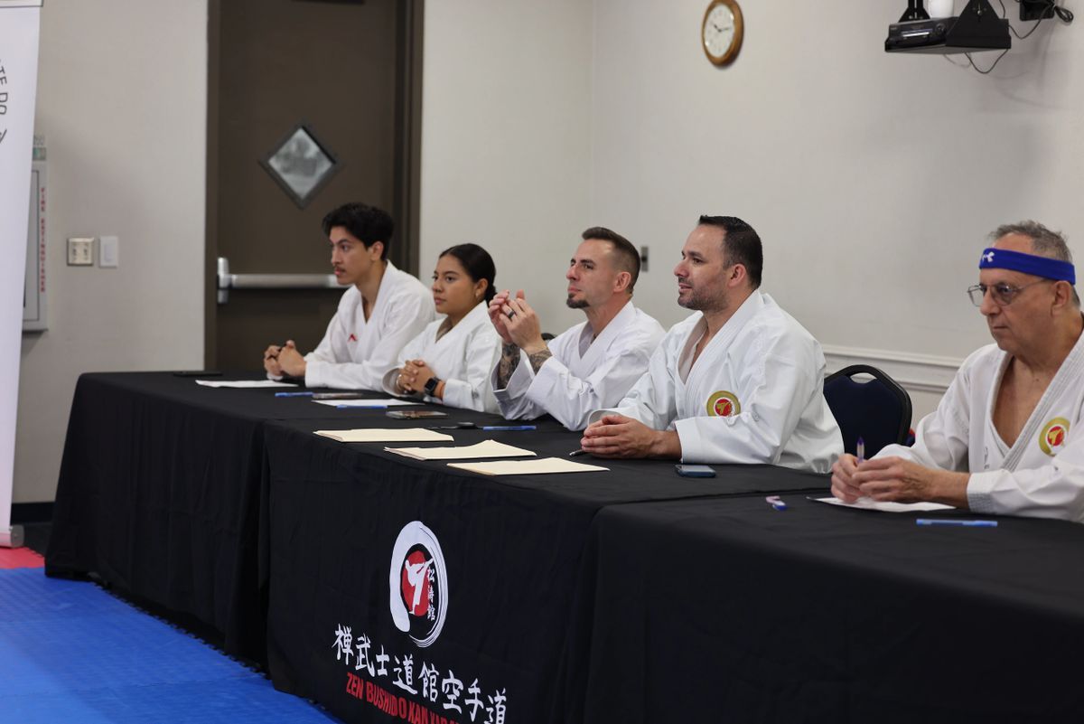 A group of people are sitting at a table with a black table cloth