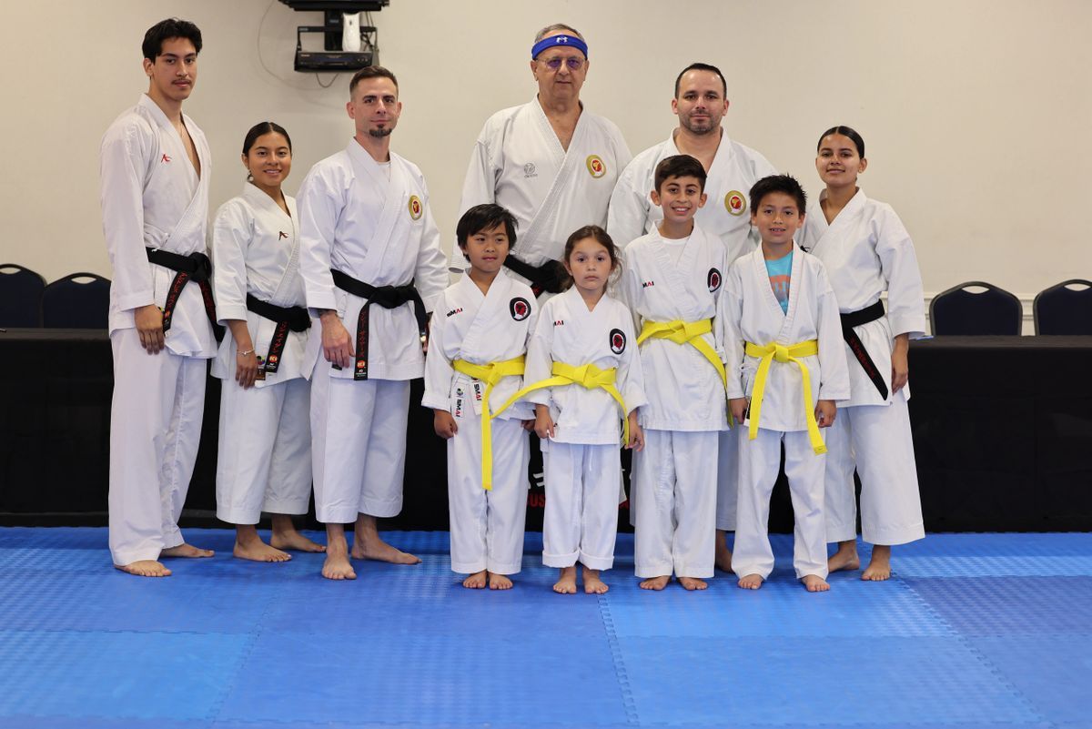 A group of people in karate uniforms are posing for a picture.