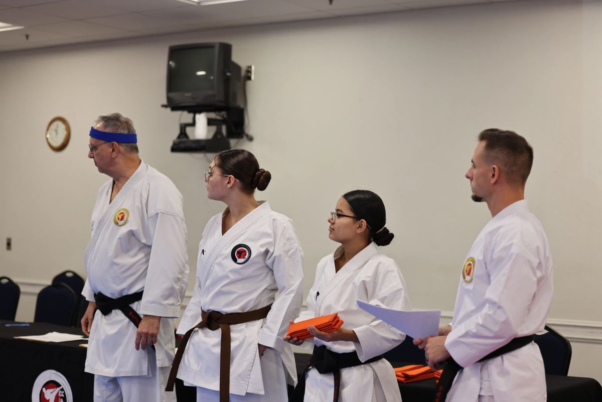 A group of people in karate uniforms are standing in a room.