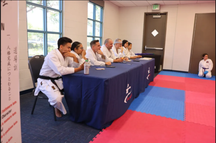 A group of people are sitting at a table with the letter t on it