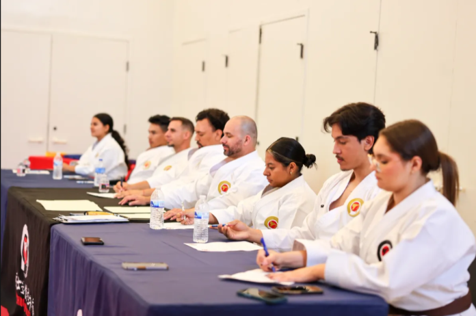 A group of people in karate uniforms are sitting at a table