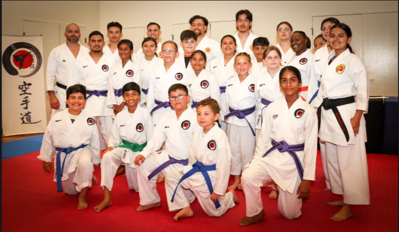 A group of people in karate uniforms pose for a picture