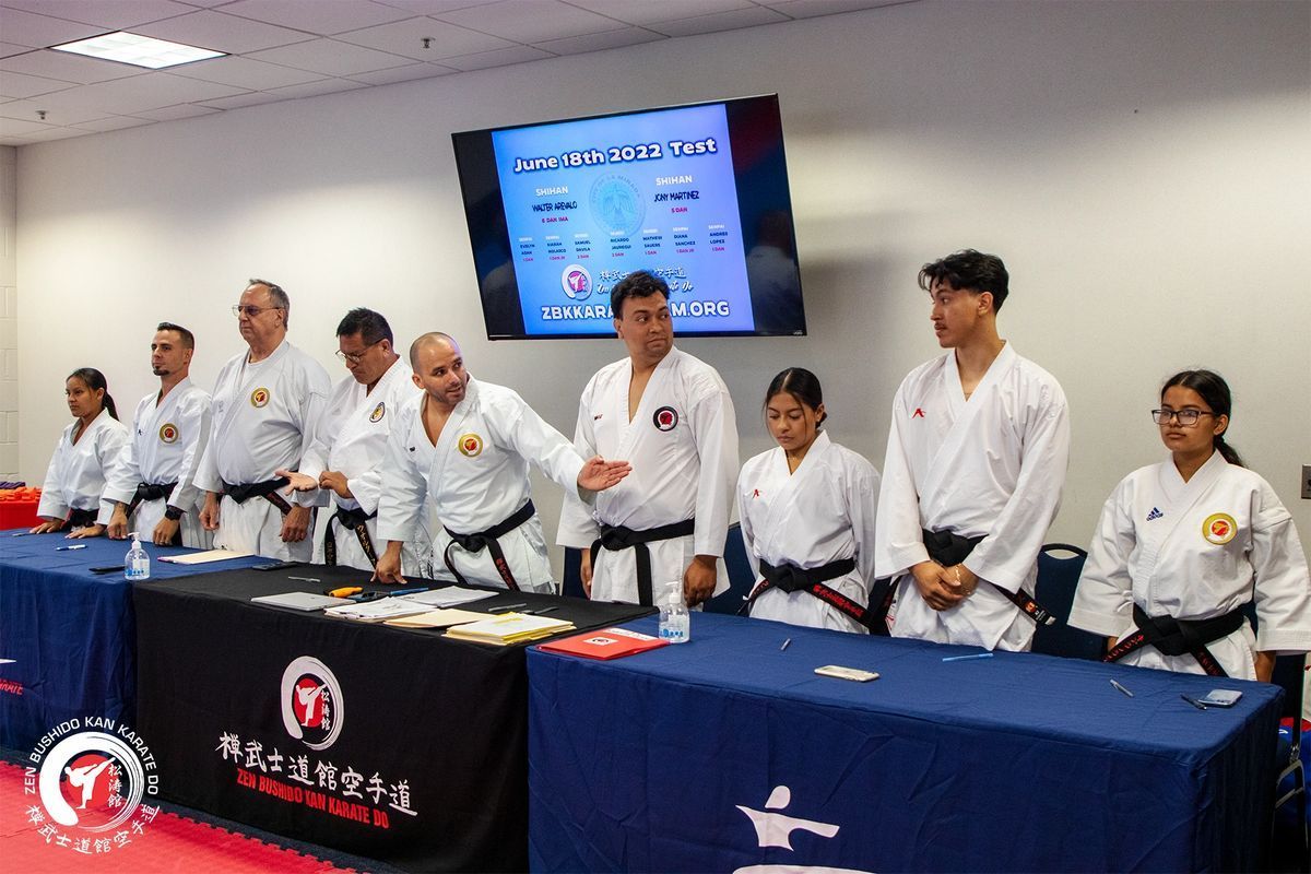 A group of people in karate uniforms are standing around a table.