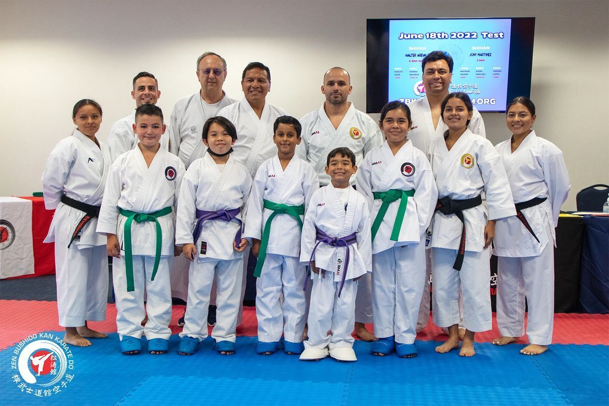 A group of people in karate uniforms are posing for a picture.