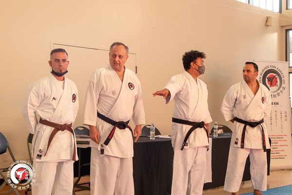 A group of men in karate uniforms are standing next to each other
