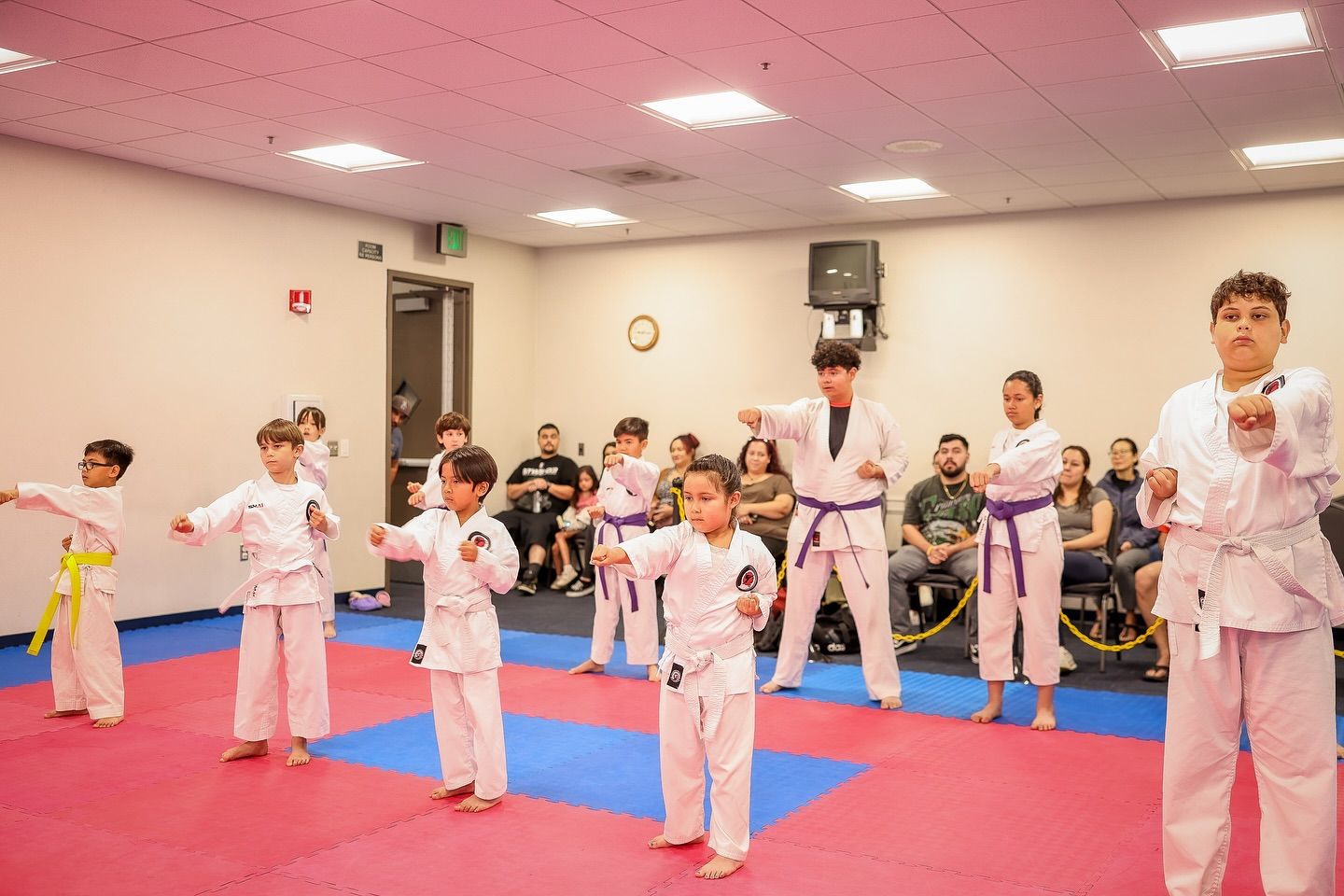 A group of young children are practicing karate in a gym.