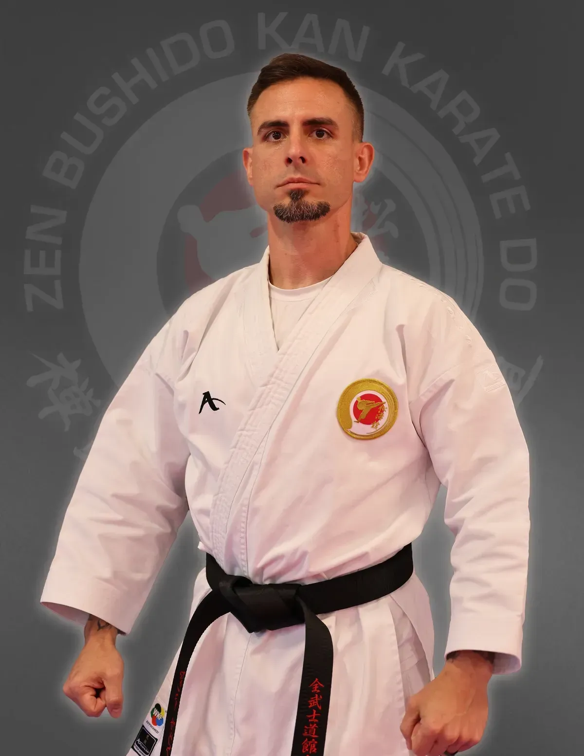 A man in a white karate uniform with a black belt