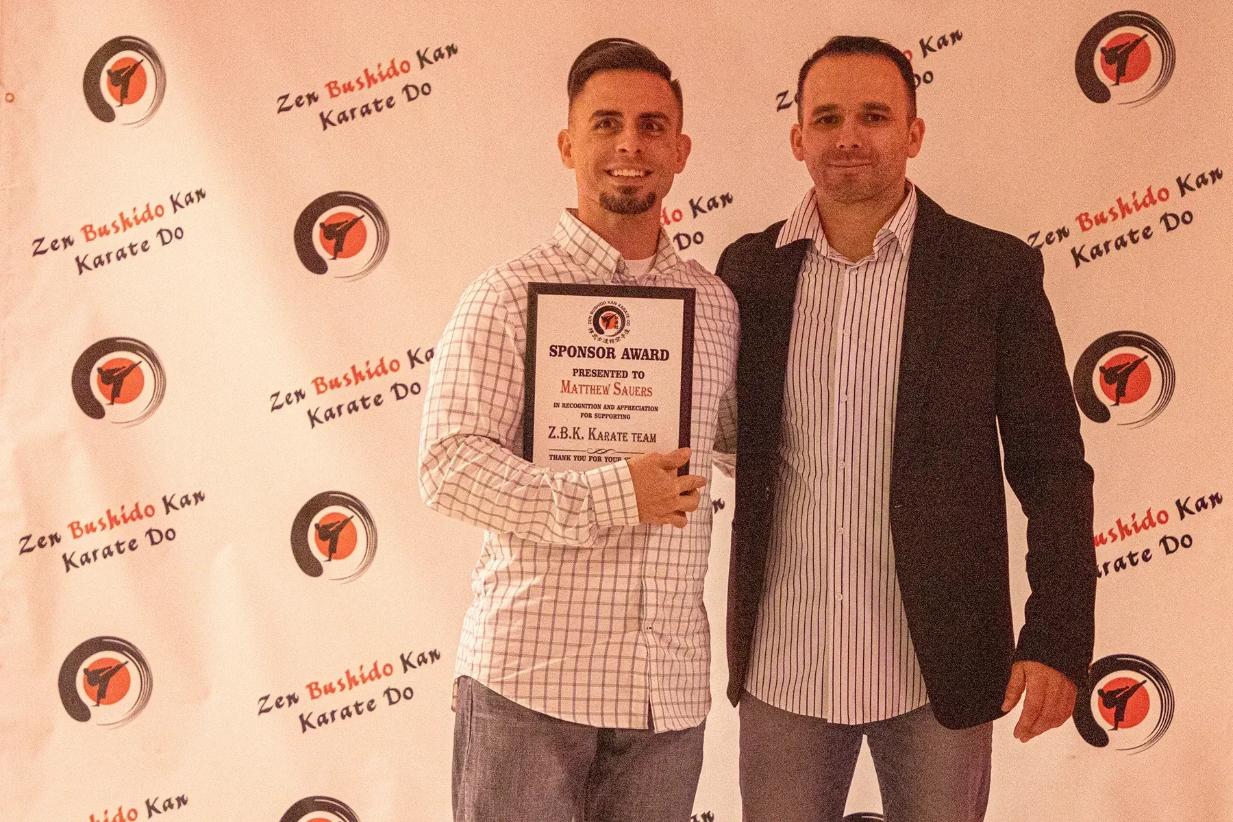 Two men are standing next to each other holding a certificate.