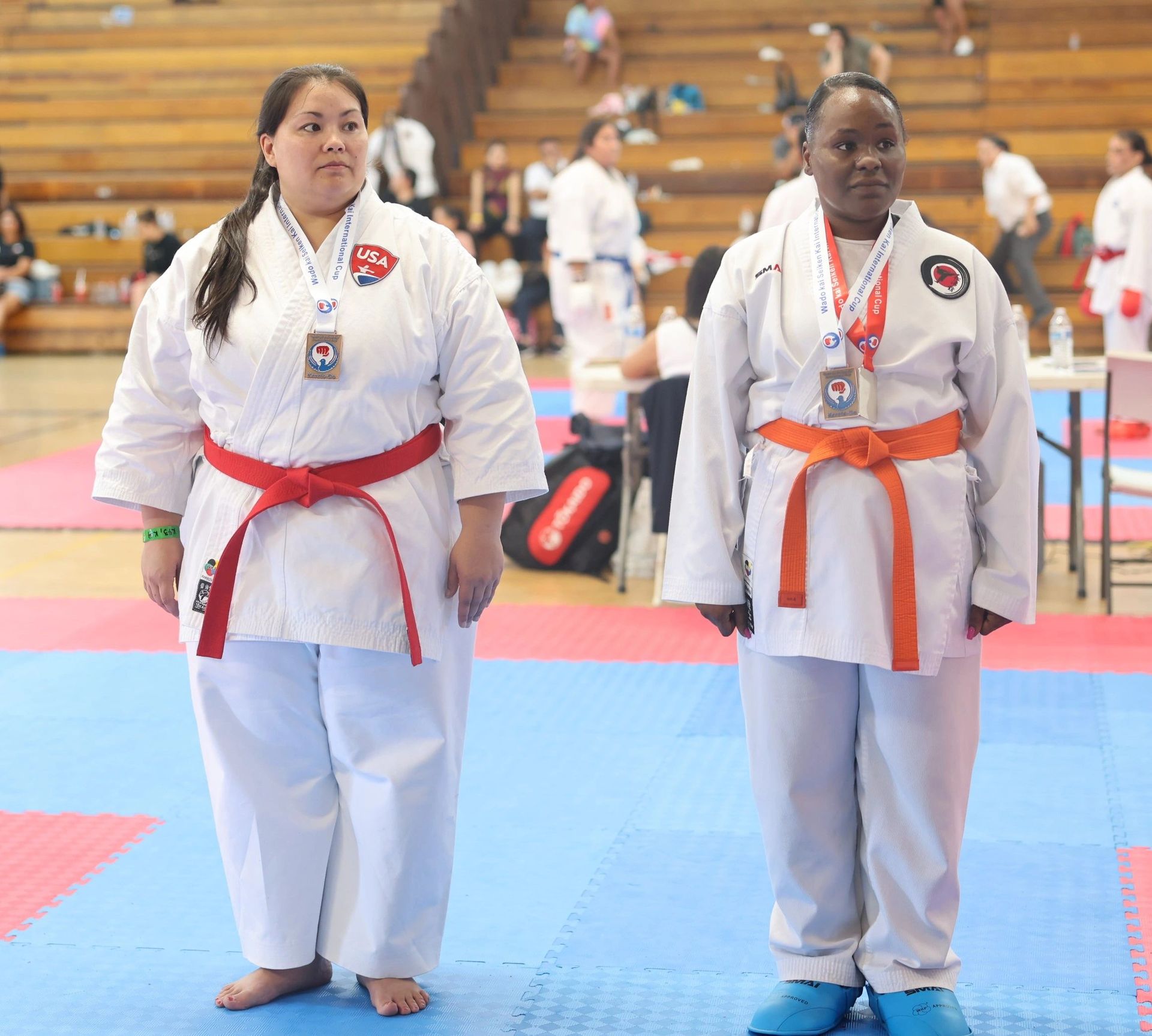 Two women in karate uniforms are standing next to each other