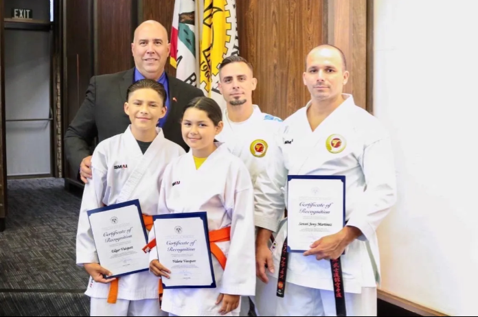 A group of people in karate uniforms are posing for a picture