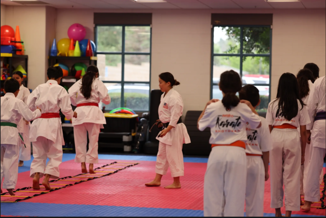 A group of kids are practicing karate in a gym