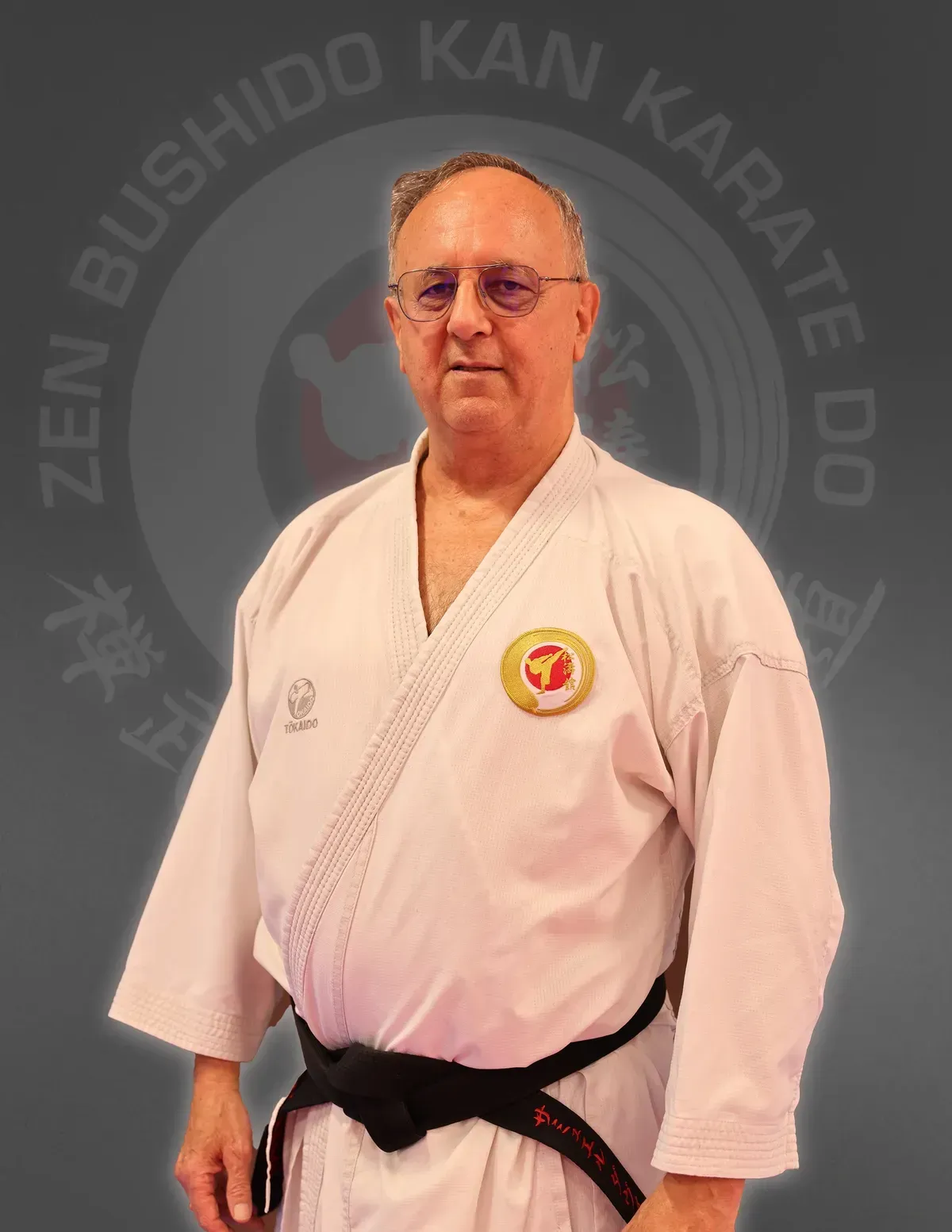 A man in a white karate uniform with a black belt