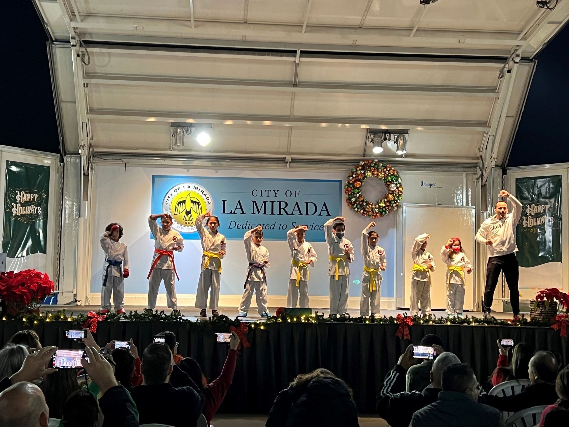 A group of children are performing on a stage in front of a crowd.
