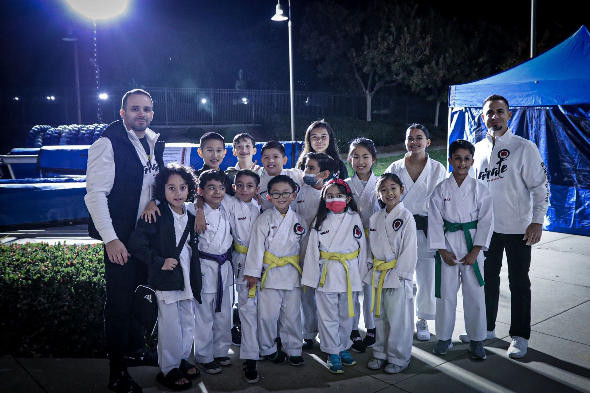 A group of children in karate uniforms are posing for a picture.