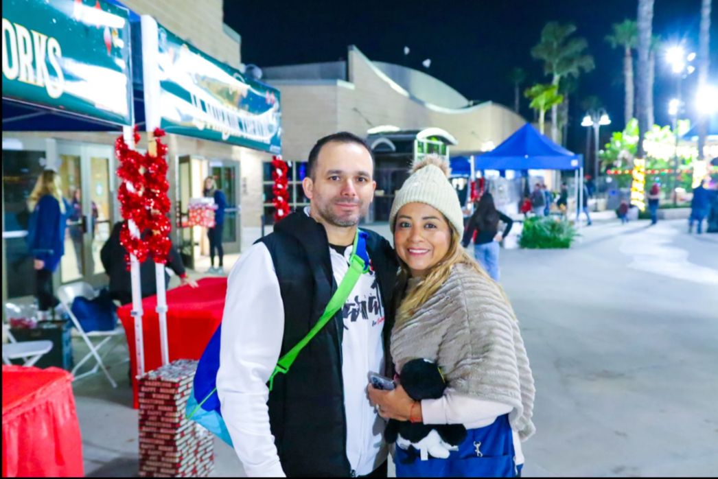 A man and a woman are posing for a picture in front of a sign that says davis