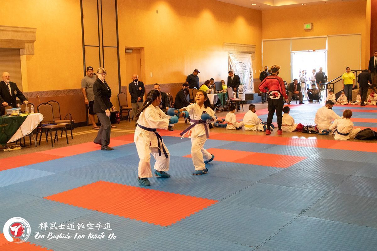 A group of kids are practicing martial arts in a gym