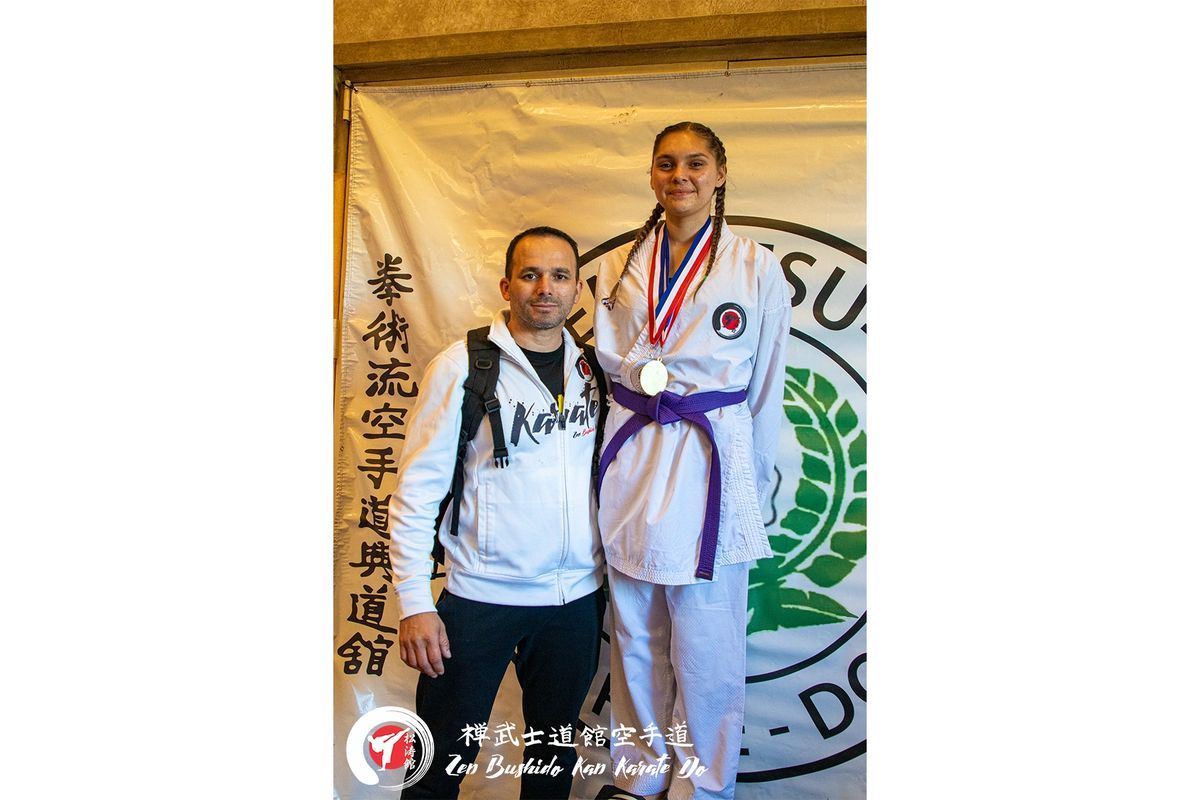 A man and a woman are standing next to each other in front of a banner.