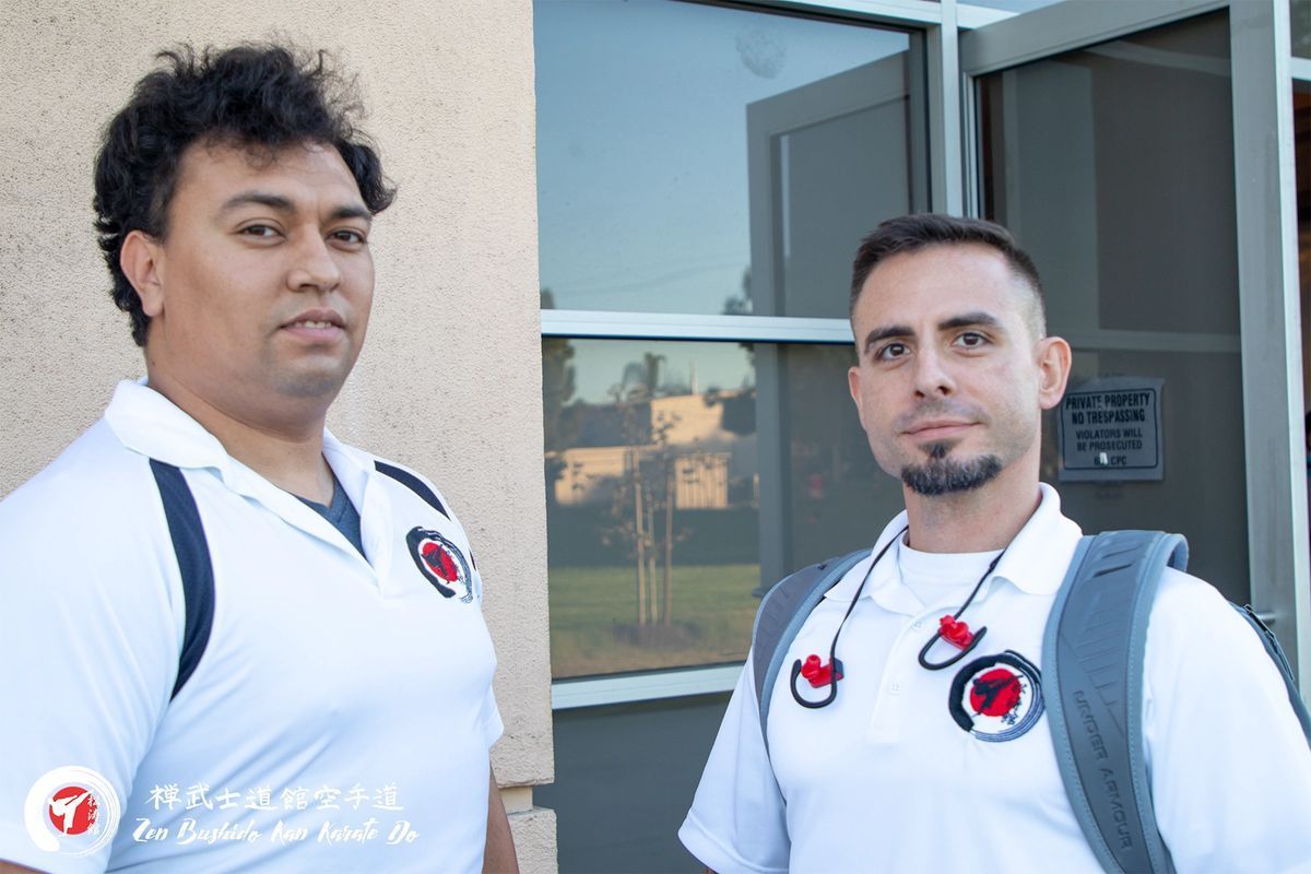 Two men are standing next to each other in front of a building