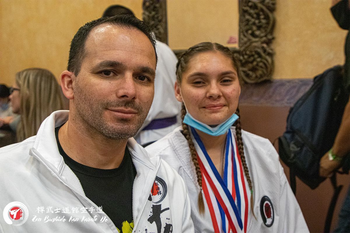 A man and a girl are posing for a picture while wearing medals.