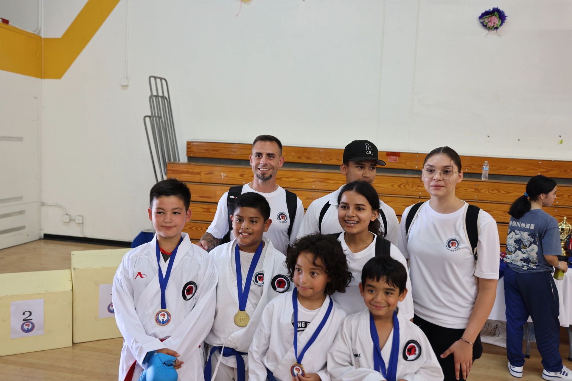 A group of people are posing for a picture in a gym.