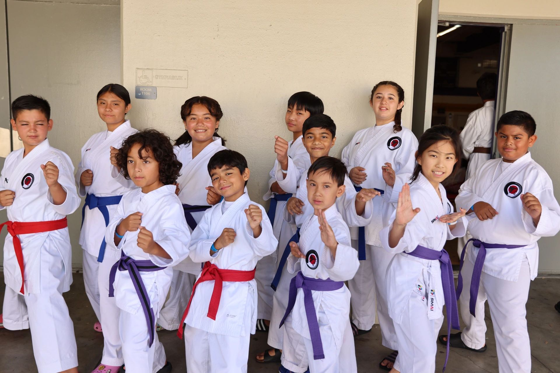 A group of children in karate uniforms are posing for a picture.