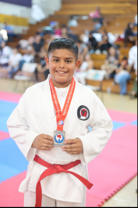 A young boy with a medal around his neck