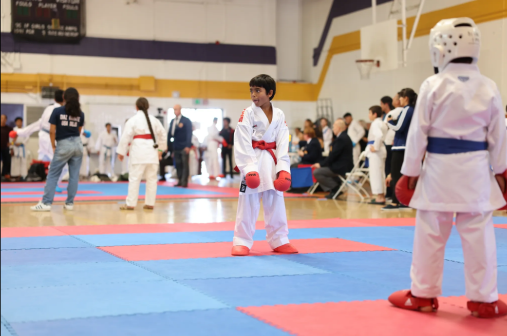 A group of kids are practicing martial arts in a gym
