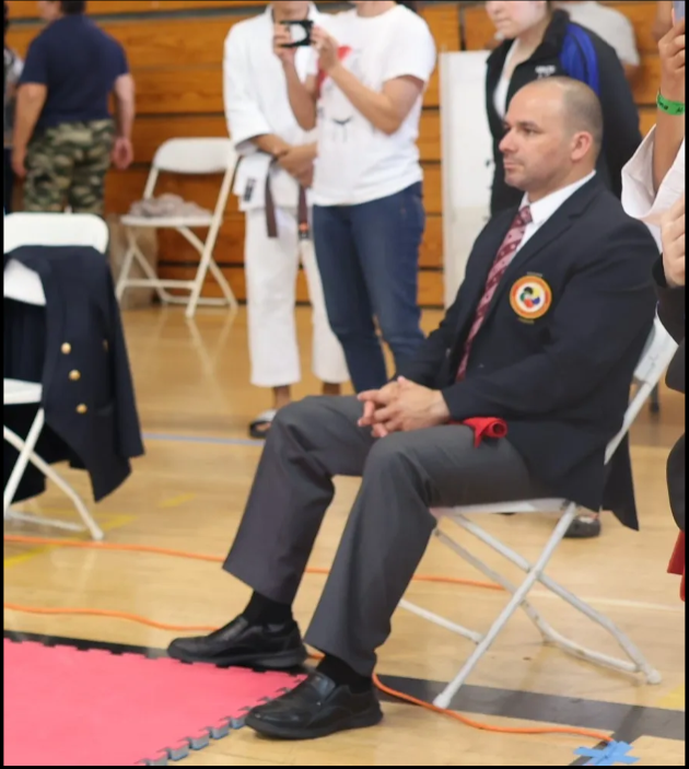 A man in a suit and tie is sitting in a chair