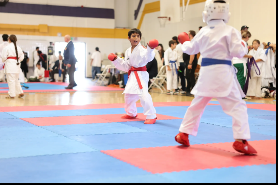 A group of kids are practicing martial arts in a gym