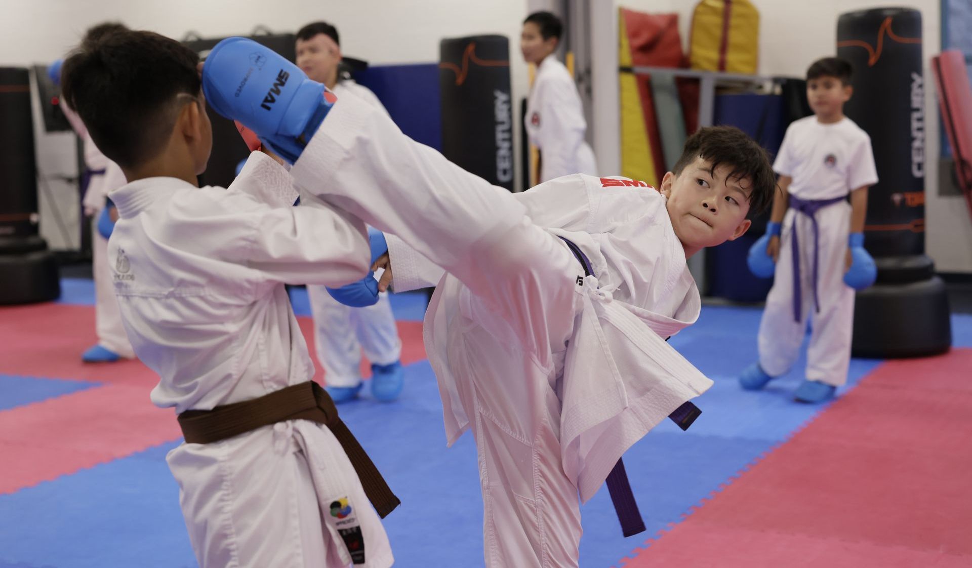 A group of people are practicing karate in a gym in La Mirada