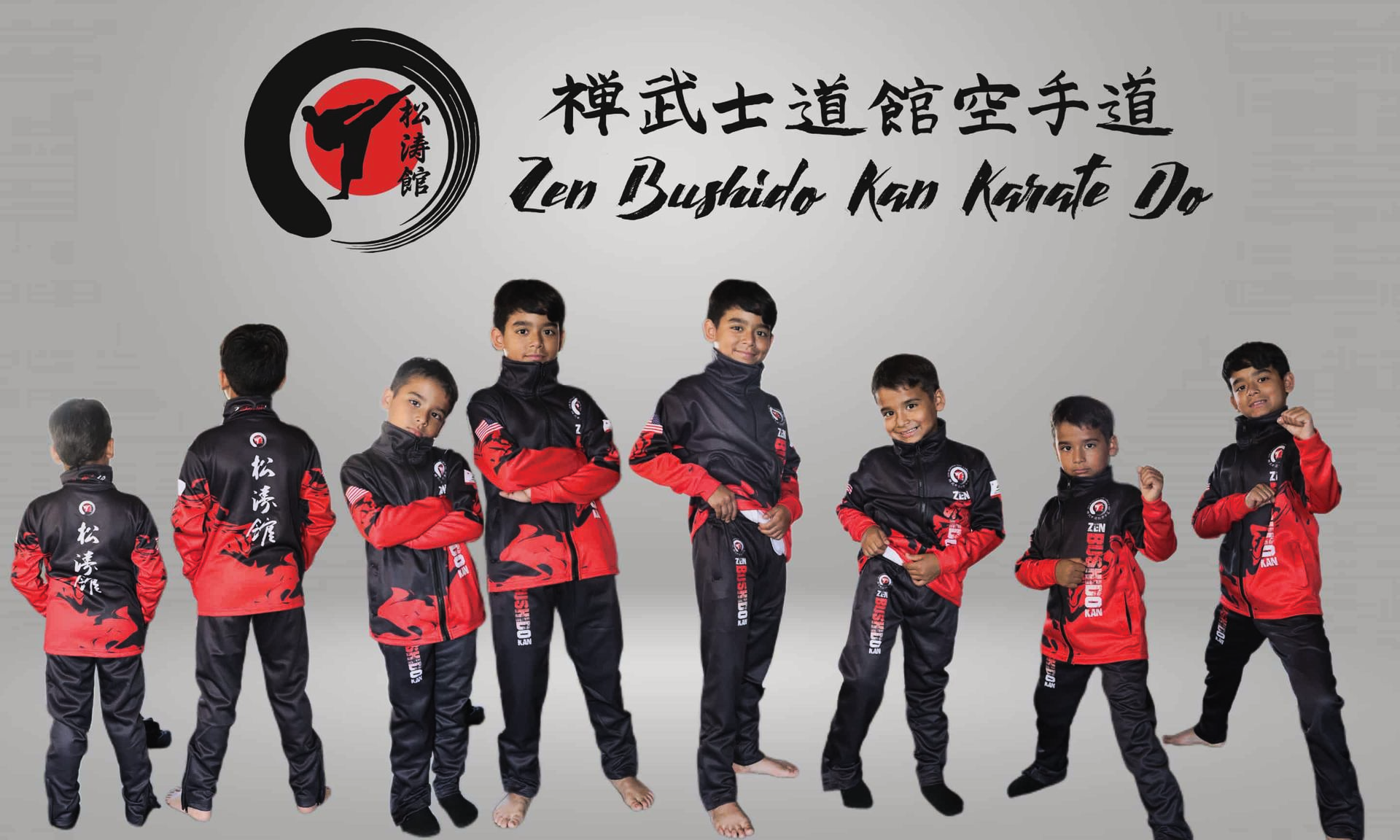 Group of children in red and black karate uniforms, posing under a dojo logo.