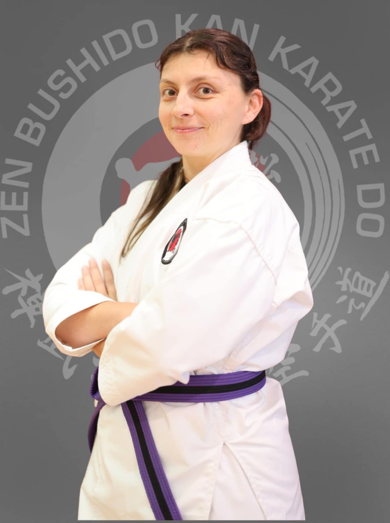 A young man in a karate uniform with his arms crossed