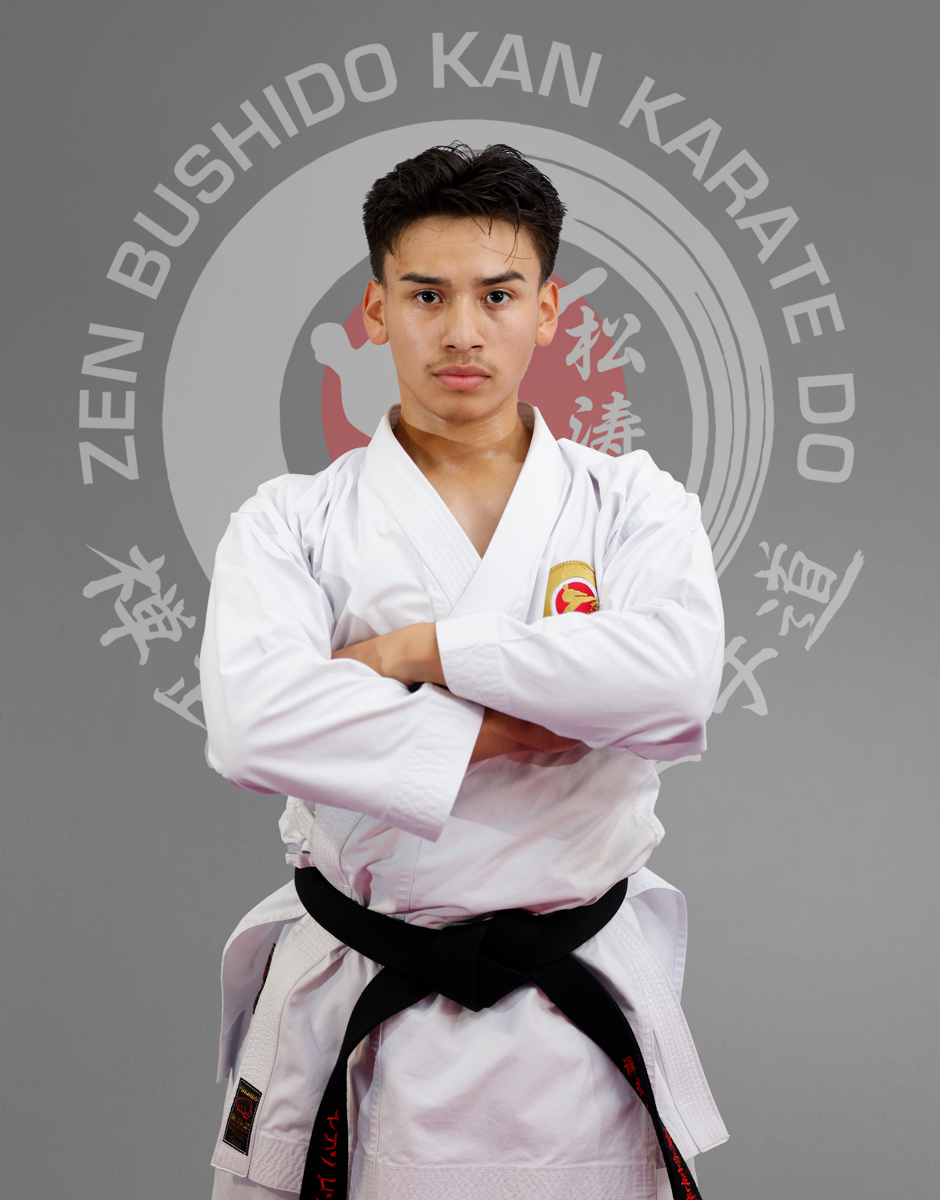 A young man in a karate uniform with his arms crossed