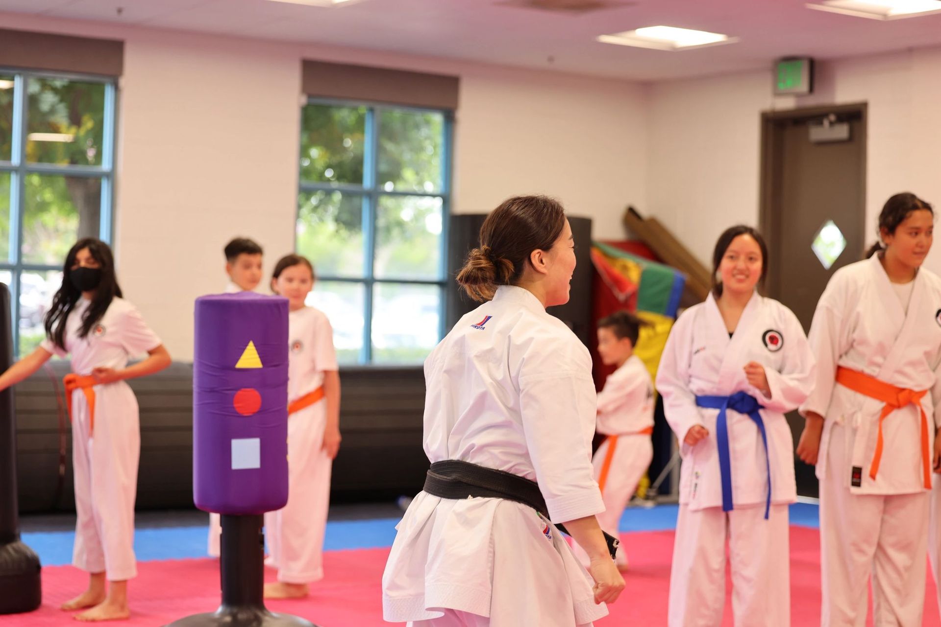A group of women are practicing karate in a gym.