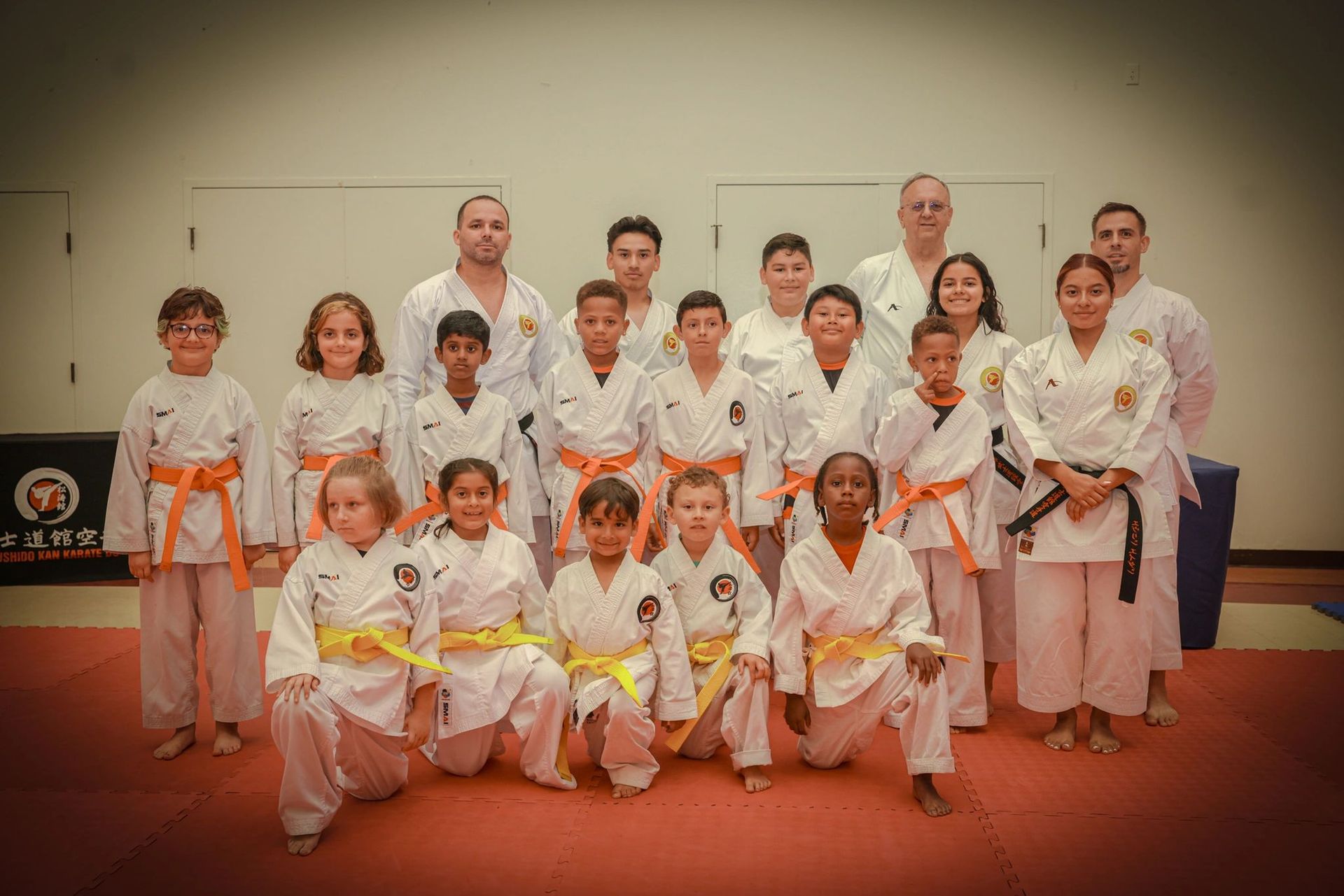 A group of children in karate uniforms are posing for a picture.